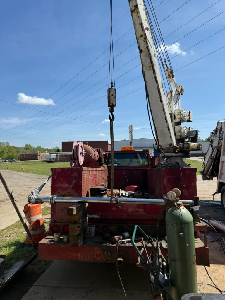 Red service truck with a crane on the bed.